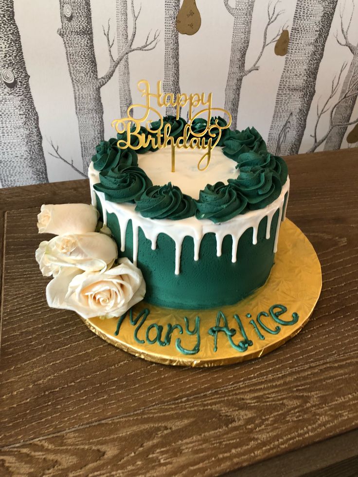 a birthday cake with green icing and white flowers