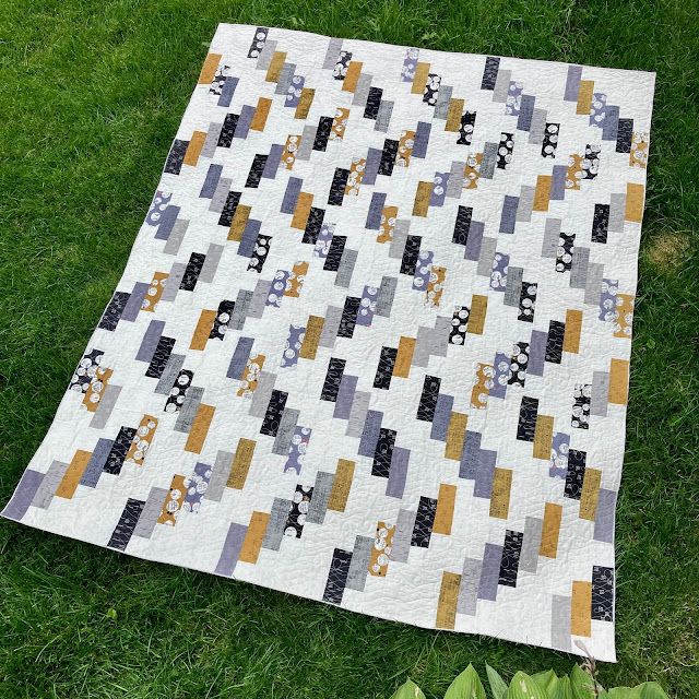 a quilt is laying on the grass