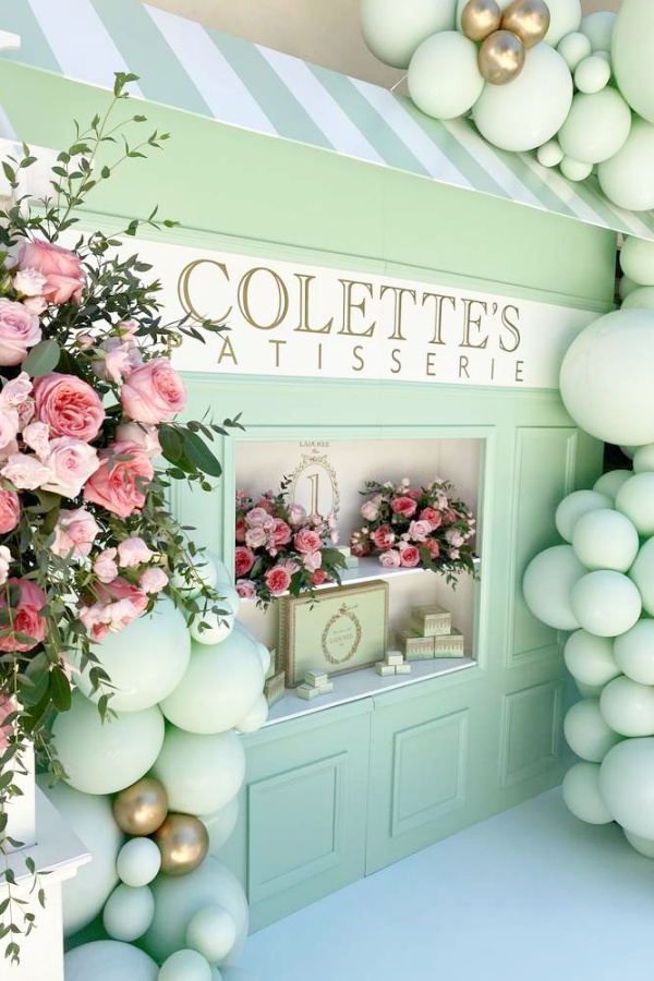 the entrance to colette's flower shop is decorated in pastel green and pink