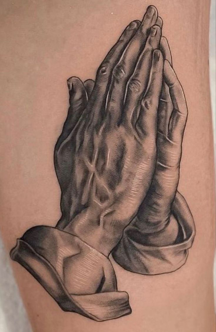 a black and white photo of a praying hands tattoo