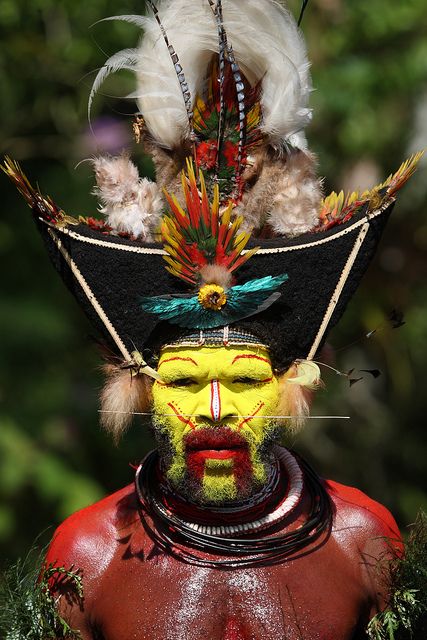 a man with painted face and feathers on his head