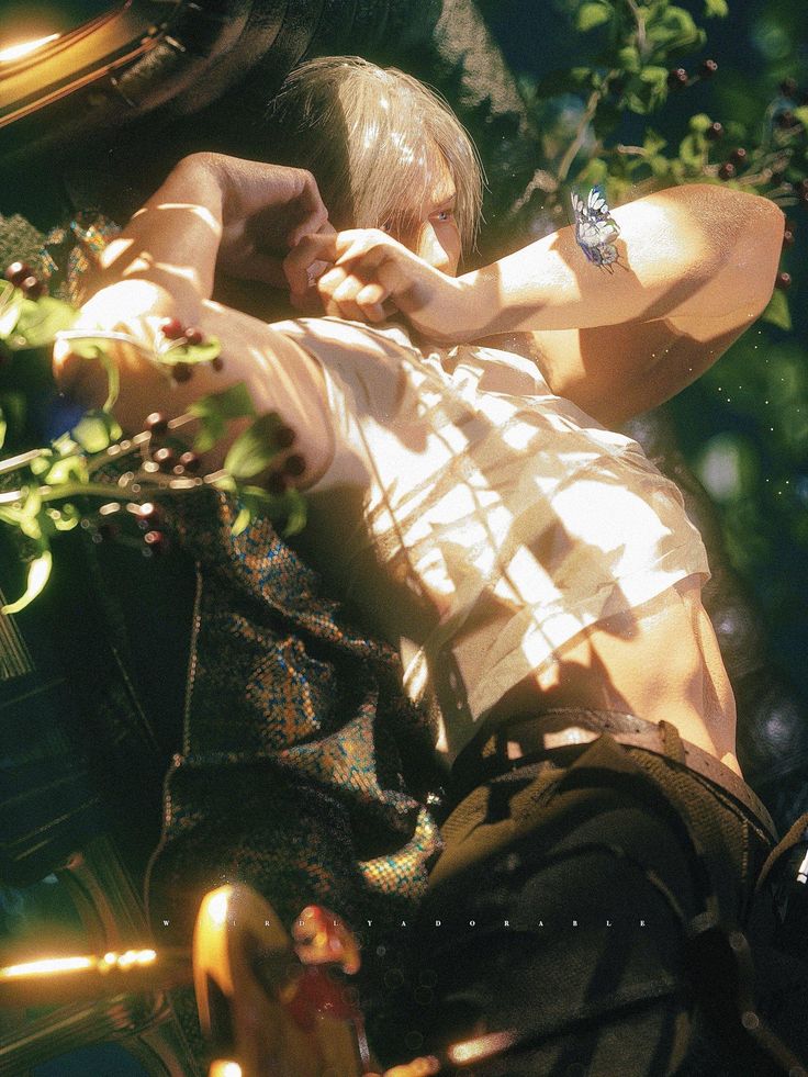 a young man is leaning against a tree and looking at his cell phone in the sunlight