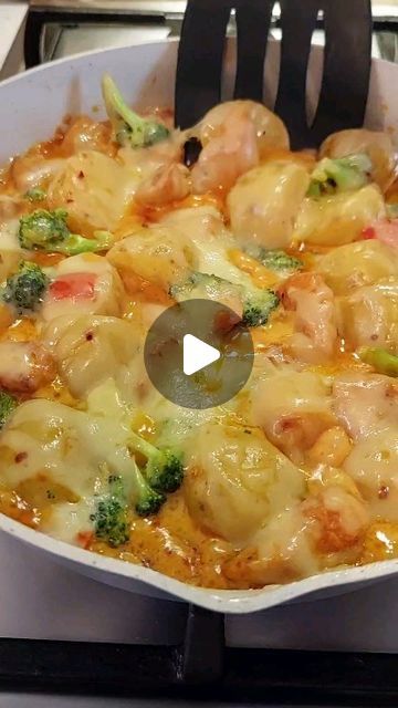 a skillet filled with pasta and broccoli on top of a stovetop