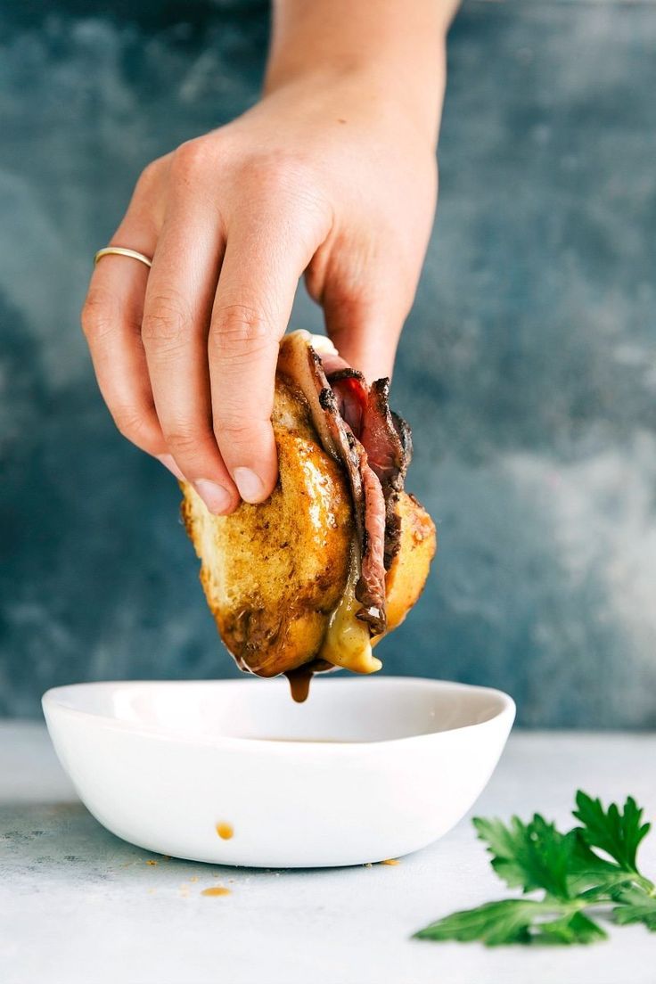 a person dipping some food into a bowl