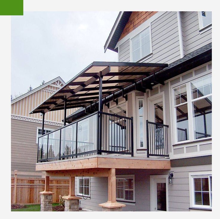 a house with a covered patio in front of it and lots of windows on the second floor