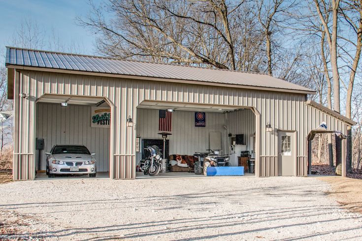 two cars are parked in front of a garage with an american flag on the roof