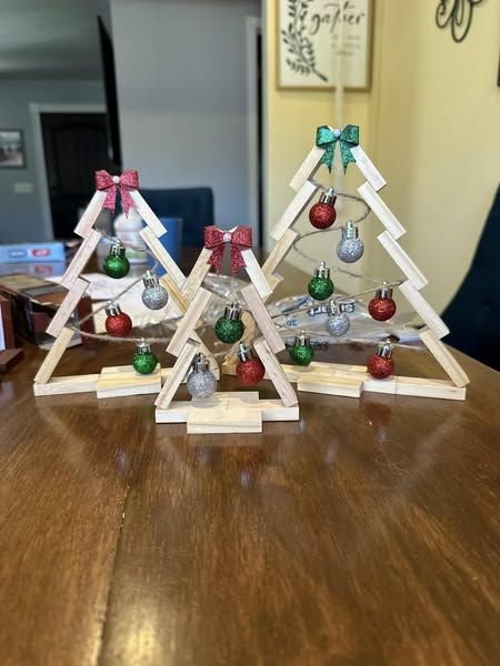 three small wooden christmas trees on a table