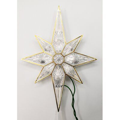 a white and gold christmas star decoration on a wall