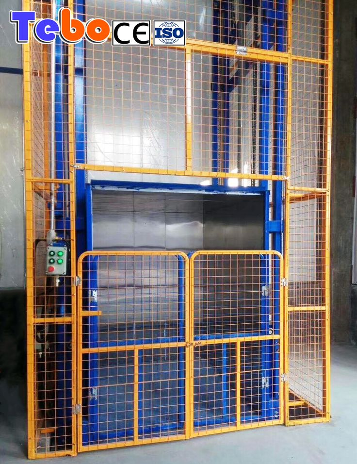 a large blue and yellow caged door in a warehouse with the words tebo ces on it