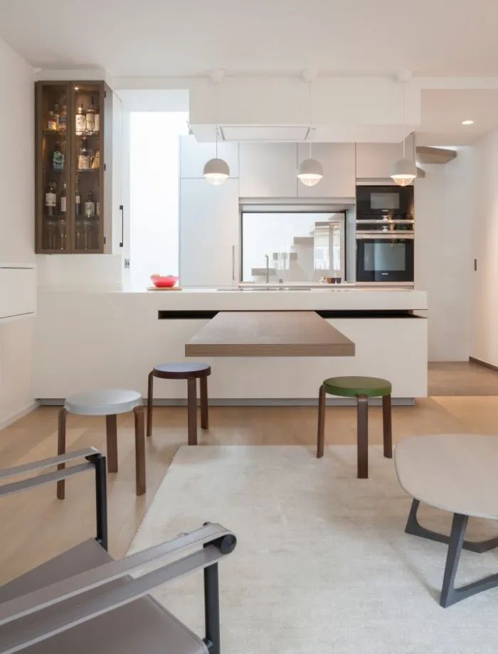 an image of a modern kitchen setting with white walls and wood flooring in the center