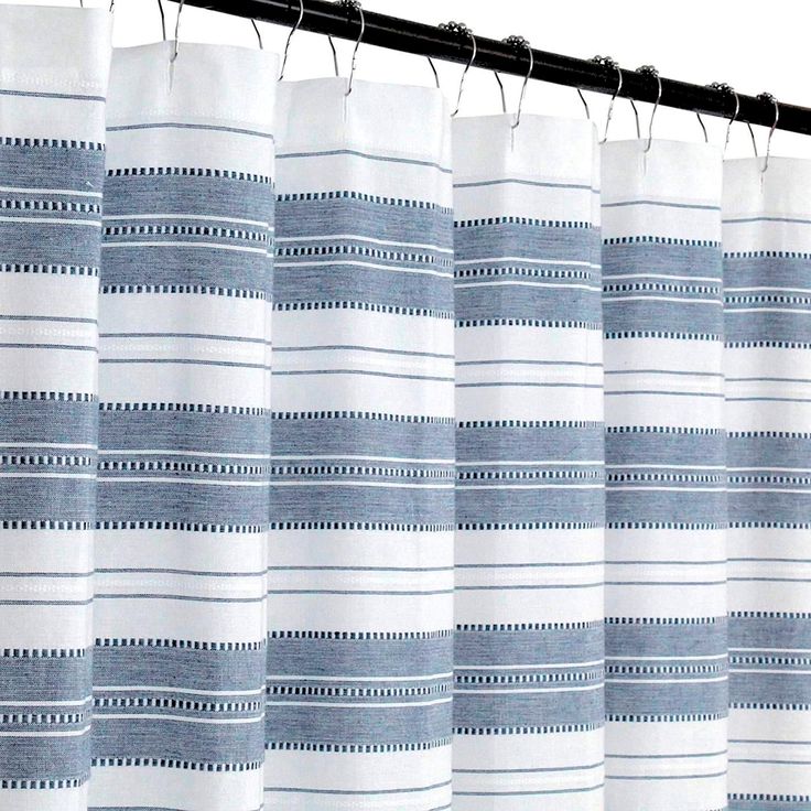 blue and white striped curtains hanging on a metal rod, with black pins in the middle