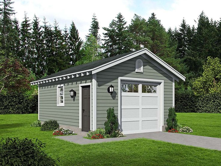 a small gray garage sitting on top of a lush green field