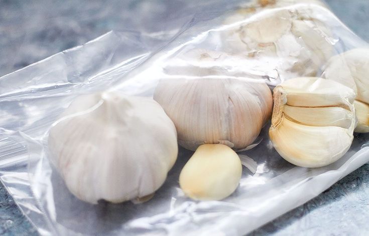 three garlics and two heads on a plastic bag