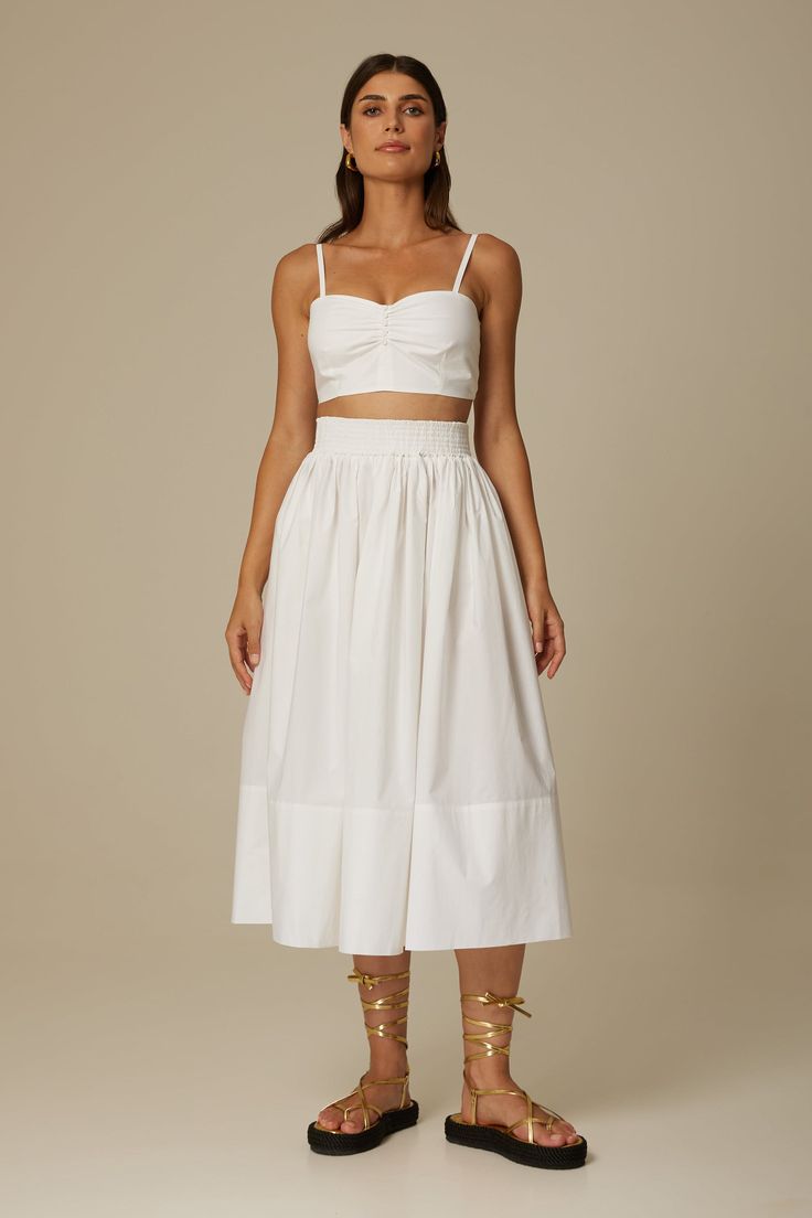 The Sofia midi skirt in crisp white is cut from Italian organic cotton poplin in a breezy full shape and features a comfortable elasticized waist, side seam pockets and a concealed zipper. Wear yours with the matching Daria bustier or one of our signature sweaters. Fit: Bianca, our model is 5.8” or 1.77 m tall and wears size 1. The skirt measures approximately 32" (80cm) long. Content: 100% organic cotton poplin. Care instructions: - For easy care, professional wash and fold is recommended. - Ma Summer Gathered Waist Midi Skirt, Summer Midi Skirt With Gathered Waist, White Midi Length Bottoms With Elastic Waistband, White Midi Bottoms With Elastic Waistband, White Bottoms With Gathered Waist For Spring, White Gathered Midi Skirt, White Cotton Midi-length Bottoms, White Cotton Midi Bottoms, White Summer Skirt With Gathered Waist