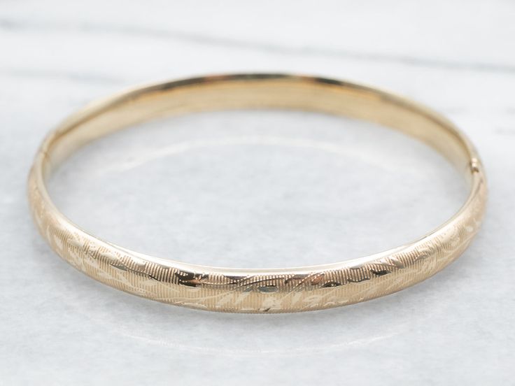 The details on this vintage 14-karat gold bangle are simply stunning! Intricate scrolling botanical designs are engraved in warm yellow gold, covering the entire bracelet. Beautiful on its own or layered with other bracelets this piece is perfect for day or evening wear.Metal: 14K Yellow GoldWidth: 6.3 mmInside Circumference: 6 1/2 InchesMarks: "JW 14K" Stamped on the inside band Classic Ceremonial Bracelet With Intricate Design, Elegant Ceremonial Bangle With Polished Finish, Classic Gold Etched Bangle, Classic Gold Bracelet With Intricate Design, Timeless Gold Engraved Bangle, Classic Gold Bracelet With Intricate Design For Anniversary, Elegant Engraved 14k Gold Cuff Bracelet, 14k Gold Bangle Bracelet With Intricate Design, 14k Gold Bangle With Intricate Design For Anniversary