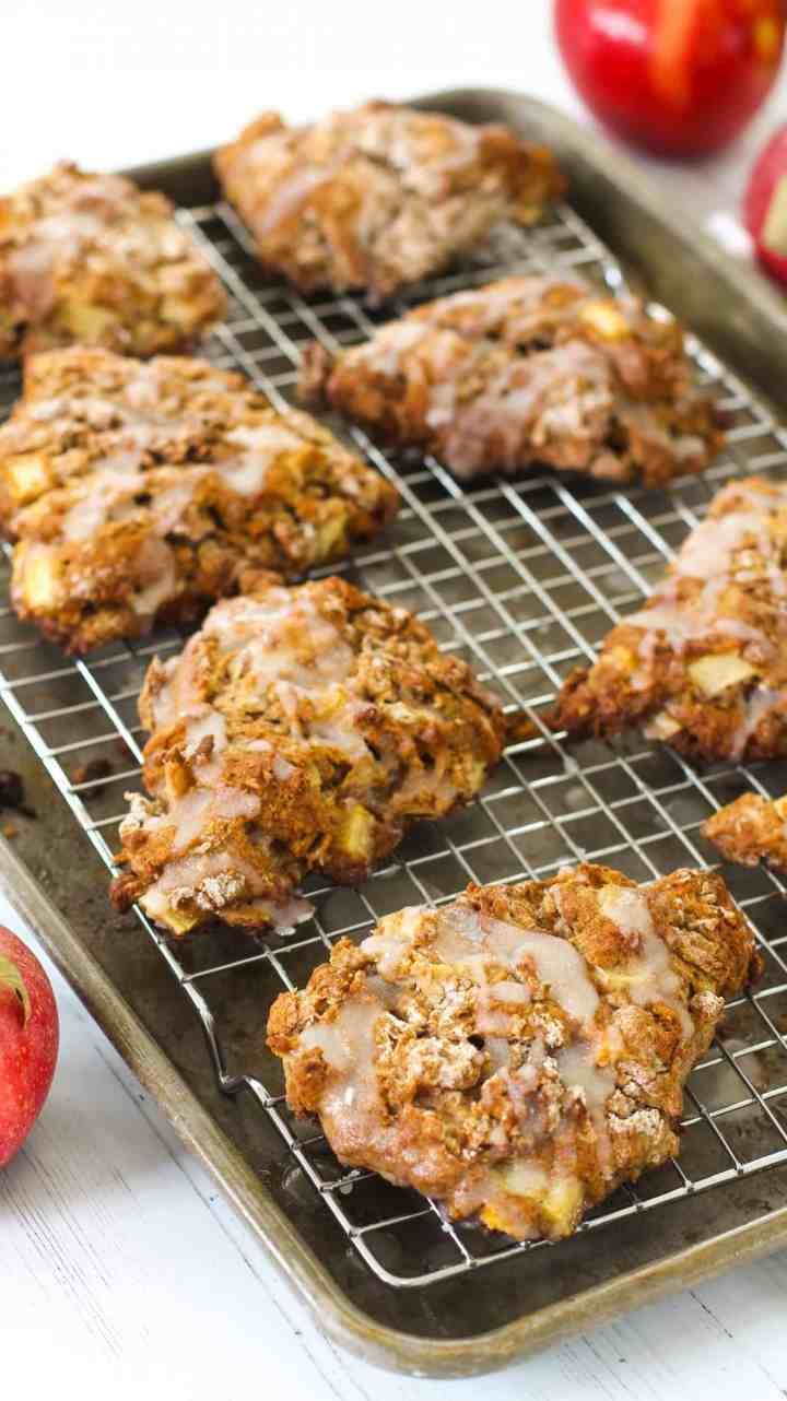 apples and cookies on a cooling rack next to an apple