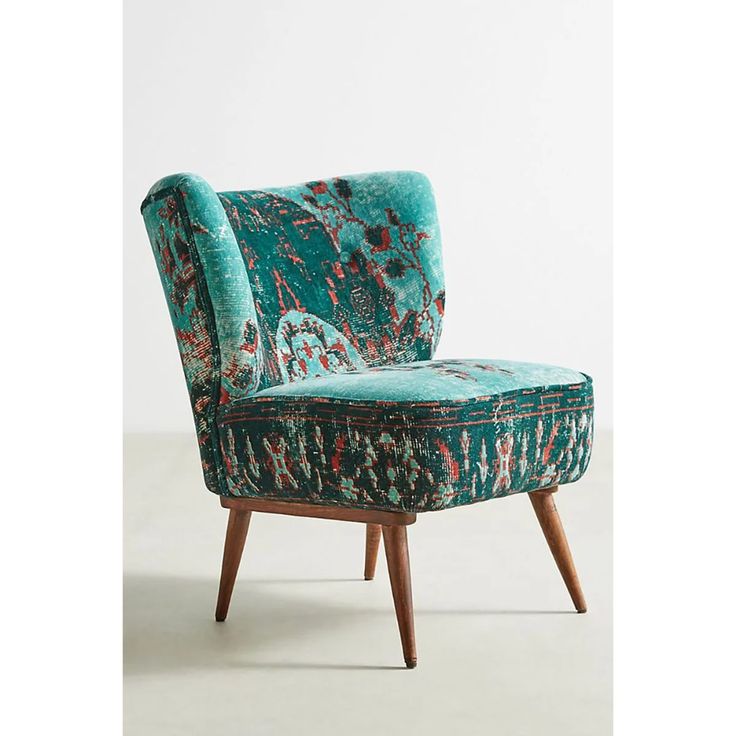 an upholstered green chair with wooden legs