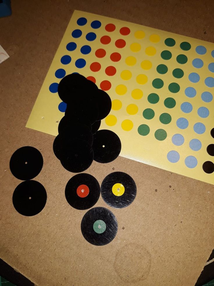 a teddy bear sitting on top of a table next to several different colored circles and buttons