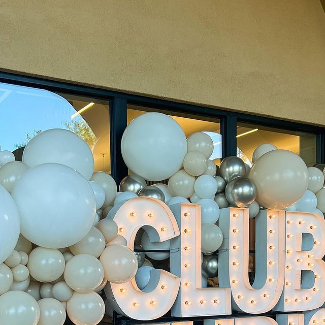 a group of balloons that are sitting in front of a sign with the word club friday written on it