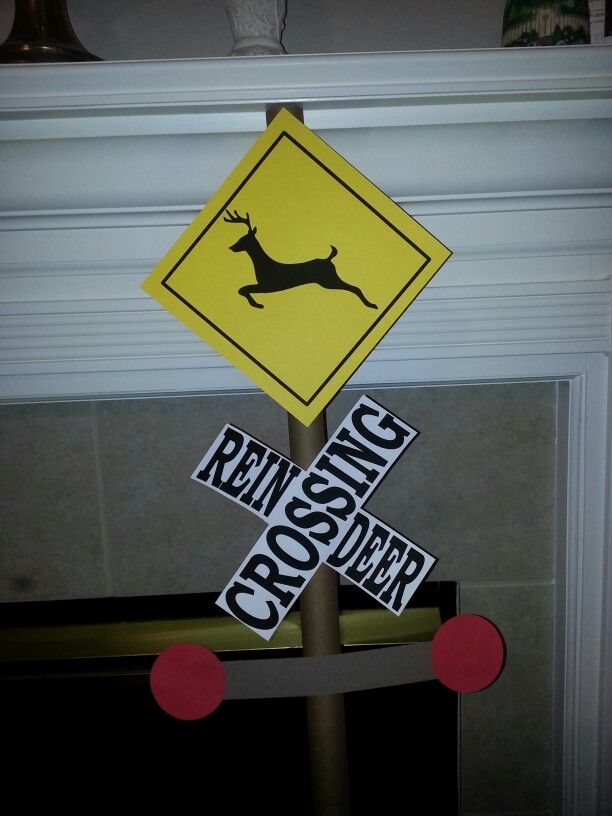 a yellow crossing sign sitting on top of a wooden pole next to a fire place