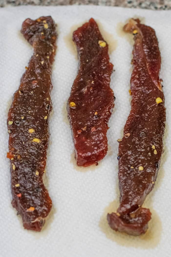 three pieces of meat sitting on top of a white towel