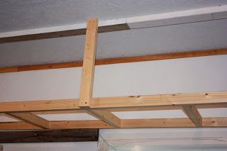 an unfinished bed frame is hanging from the ceiling