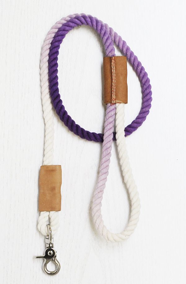 a purple and white leash with a leather hook