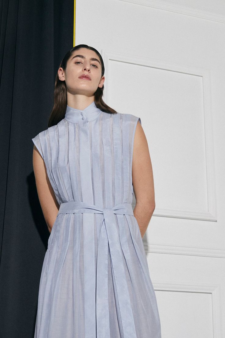 The Luna pleated shirt dress in a beautiful lightweight Cotton |Silk is an elevated, and uniquely designed dress for that special occasion. This fully lined style features a box pleated front and back, with a concealed button front opening, concealed front opening, and modern collar stand. Includes matching sash belt for optional wear.NB: Dress comes fully lined. Model is wearing an un-lined sample.Colour: Ice Blue Fit: Loose fit silhouette.Model is wearing a Size S / AU8 Knife Pleated Dress, Classic Essence, Helmut Lang Dress, Flamboyant Gamine, Pleated Shirt Dress, Knife Pleat, Garment Care Labels, Pleated Shirt, Clothing Sites