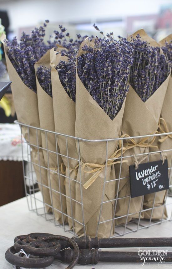 lavenders in paper bags are sitting in a basket on a table next to a pair of wrenches