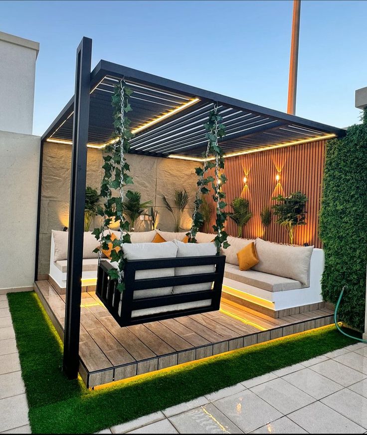 an outdoor living area with couches and potted plants on the roof terrace at dusk