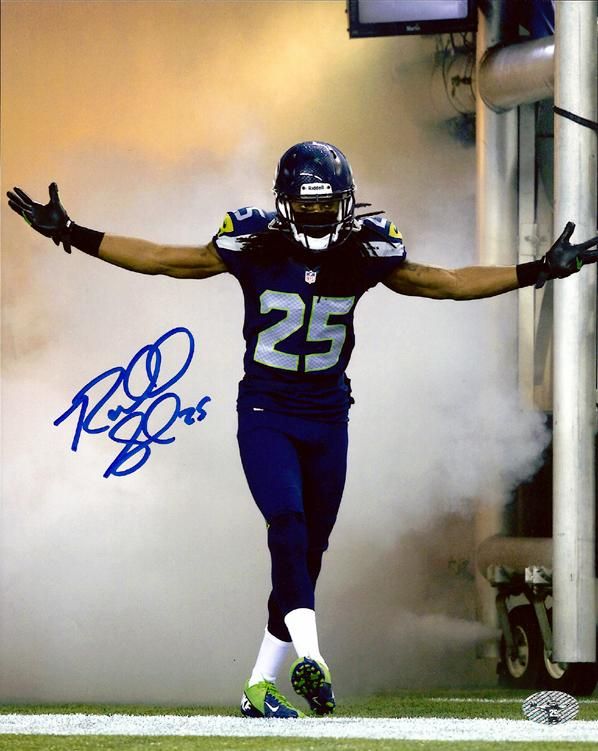 an autographed photograph of a football player jumping in the air with his arms outstretched