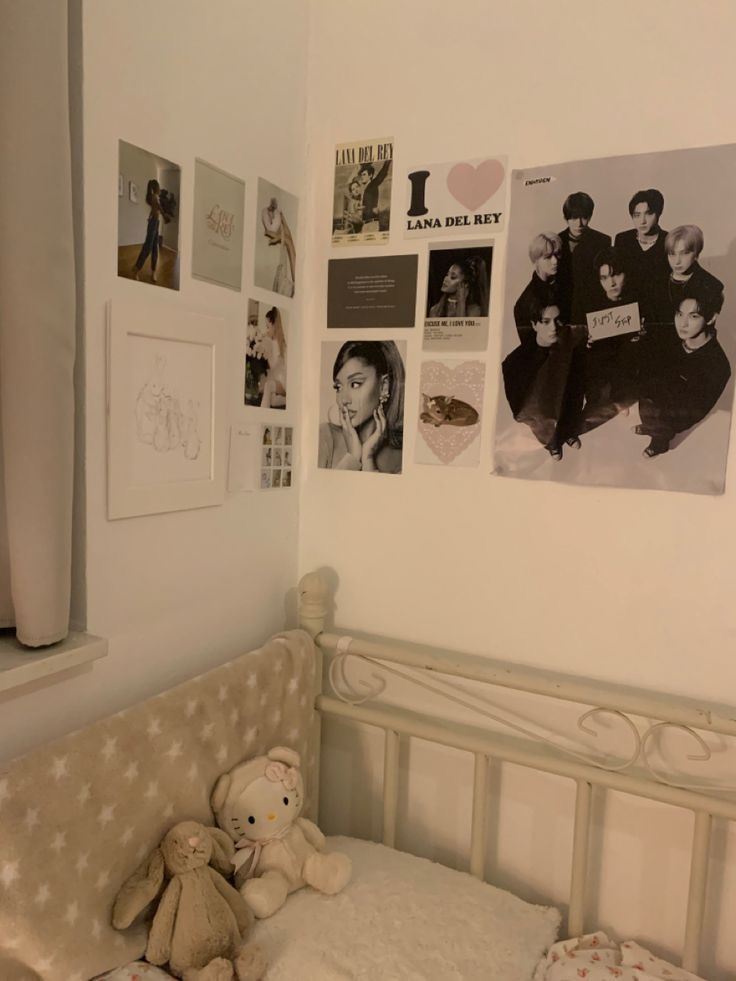 there is a teddy bear sitting on the bed in this room with many pictures and photos