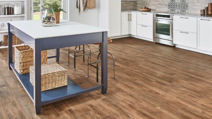 a kitchen with white cabinets and wooden floors