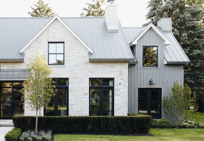 a white brick house with black trim and windows