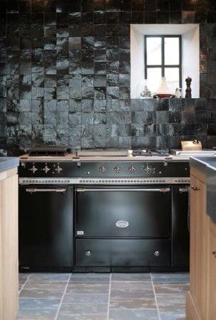 a black stove top oven sitting inside of a kitchen next to a sink and counter