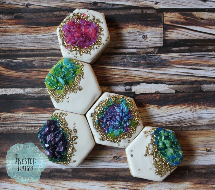 four decorated cookies sitting on top of a wooden table