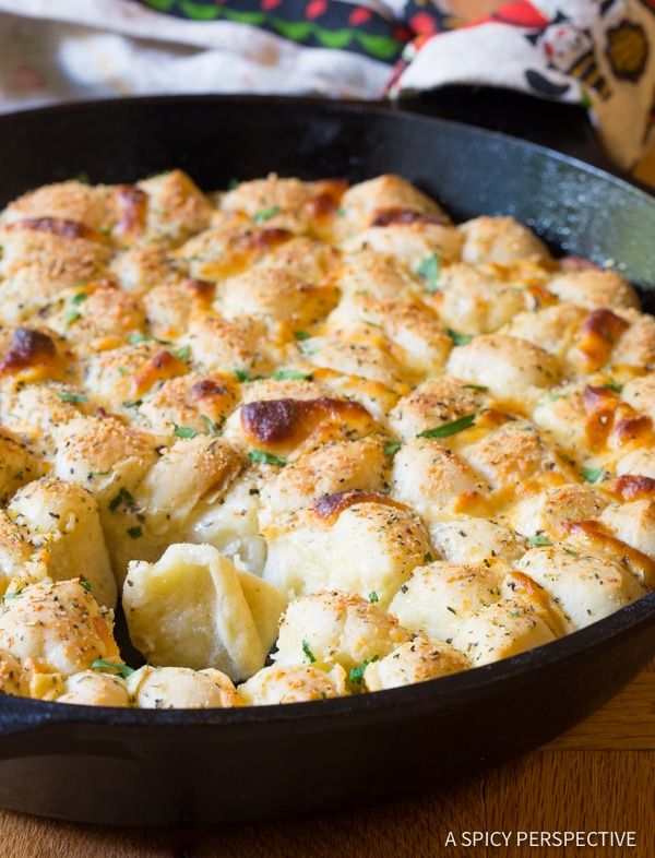 a casserole dish with potatoes and cheese in a black pan on a wooden table