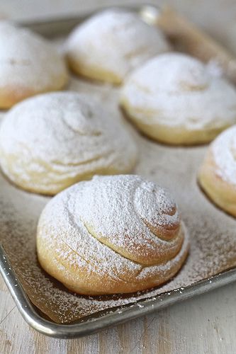 powdered sugar covered pastries on a baking sheet