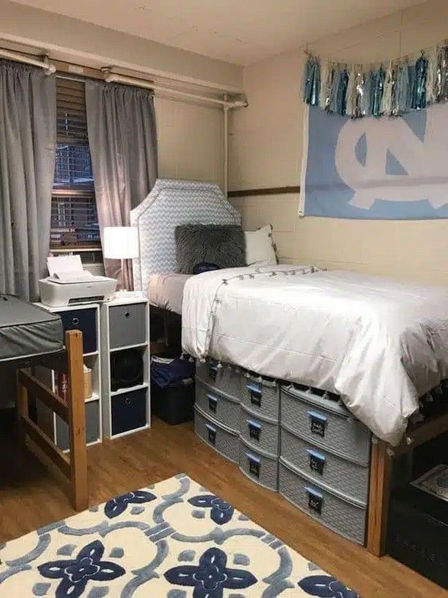 a dorm room with two beds and drawers