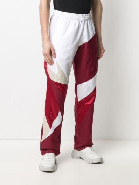 Shop red Reebok colour-block cotton track pants with Express Delivery - Farfetch White Color Block Bottoms For Streetwear, White Gym Bottoms With Side Stripes, White Joggers For Jogging, White Joggers With Elastic Side Panels, White Joggers With Elastic Side Panels For Jogging, Sporty Cotton Color Block Sweatpants, Sporty Color Block Cotton Sweatpants, White Sportswear Joggers With Side Stripes, White Color Block Cotton Pants