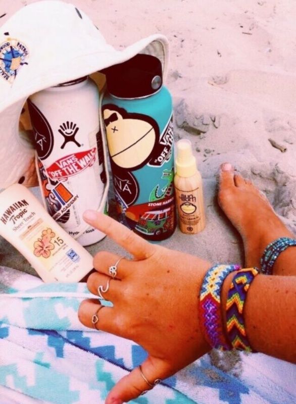 a person on the beach with sunscreen and other items