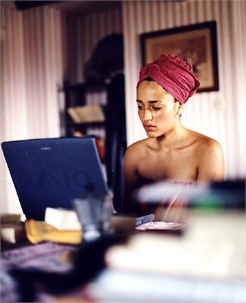 a woman sitting in front of a laptop computer