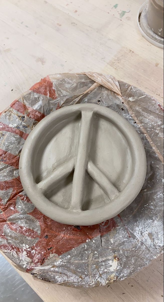 a cement peace sign sitting on top of a wooden table