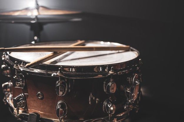 a close up of a drum on a black background with a lamp in the background