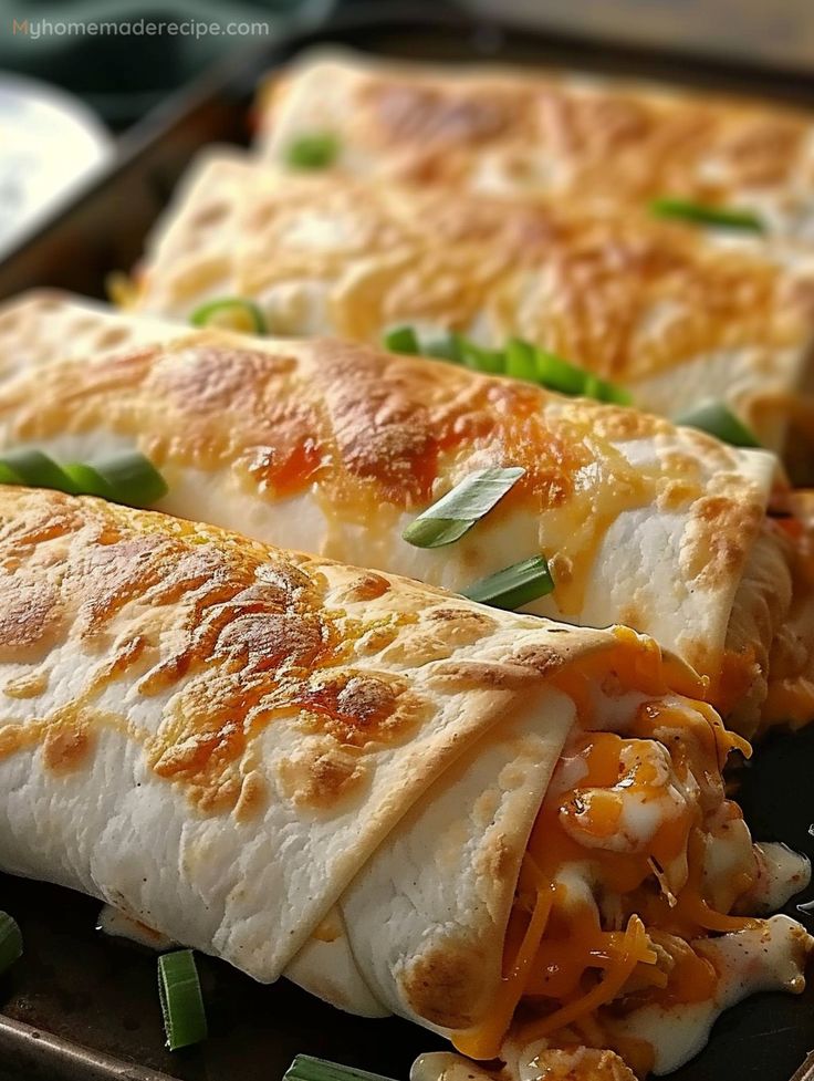 two quesadillas with cheese and green onions on a black plate, ready to be eaten