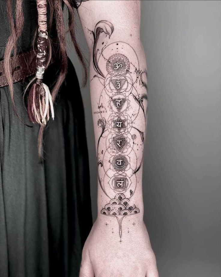 a woman's arm with a tattoo on it and an intricate design in the middle