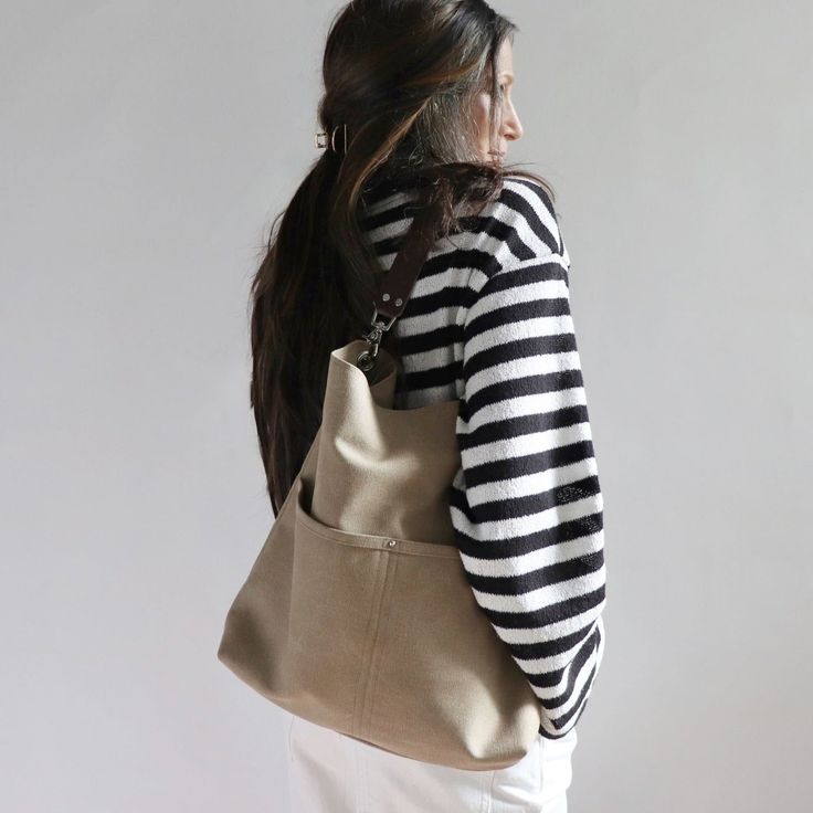 The best tote bags combine casual style with useful functionality in an easy to carry shape. Our canvas hobo bag gets it all just right. Modern and minimalist with lots of pockets in all the right places. Plenty of interior space with just the right amount of slouch so the bag never feels too big.Durably handcrafted with attention to detail in the perfect neutral khaki color that goes with everything.This listing is for the Large size as pictured. Coming soon in Medium and Mini sizes too.Details