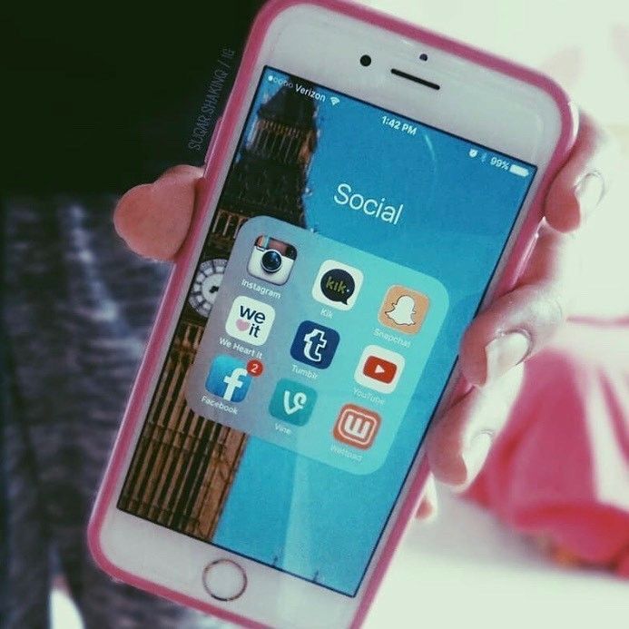 a person holding an iphone in their hand with social icons on the screen and big ben in the background