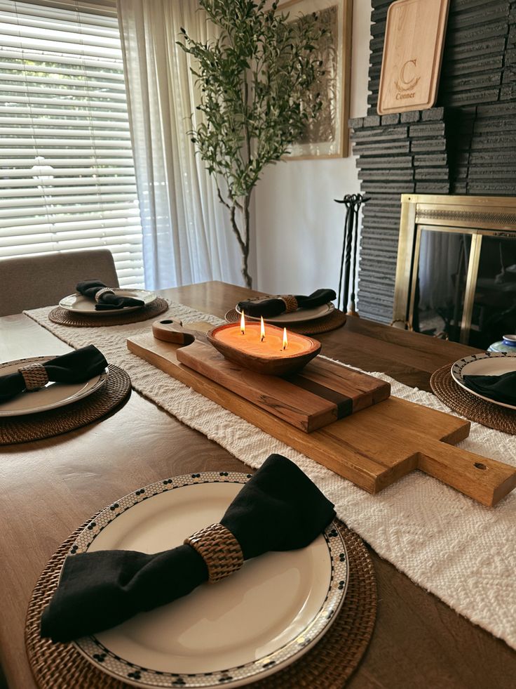 a wooden table topped with plates and candles