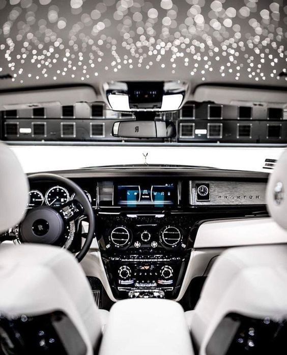 the interior of a car with white leather seats and black dash lights on the ceiling